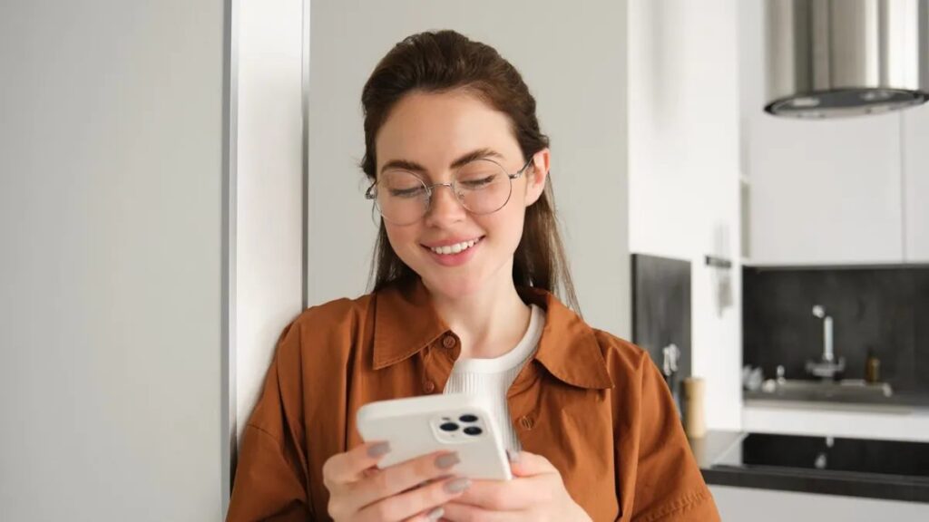 Woman calmly reading a message on her phone — high-conflict co-parenting communication