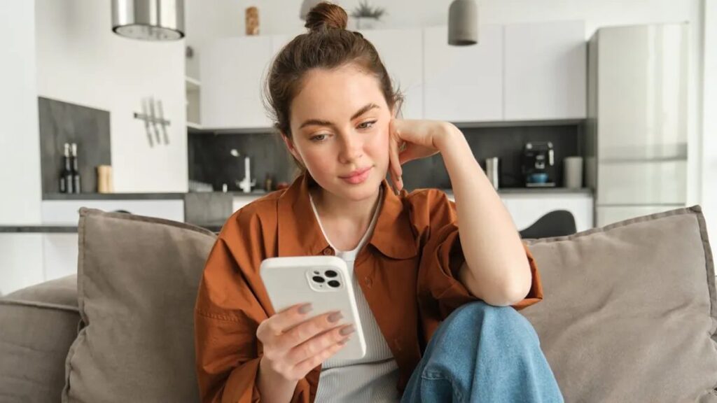 Woman calmly writing a short text message to a co-parent — high-conflict co-parenting communication tips